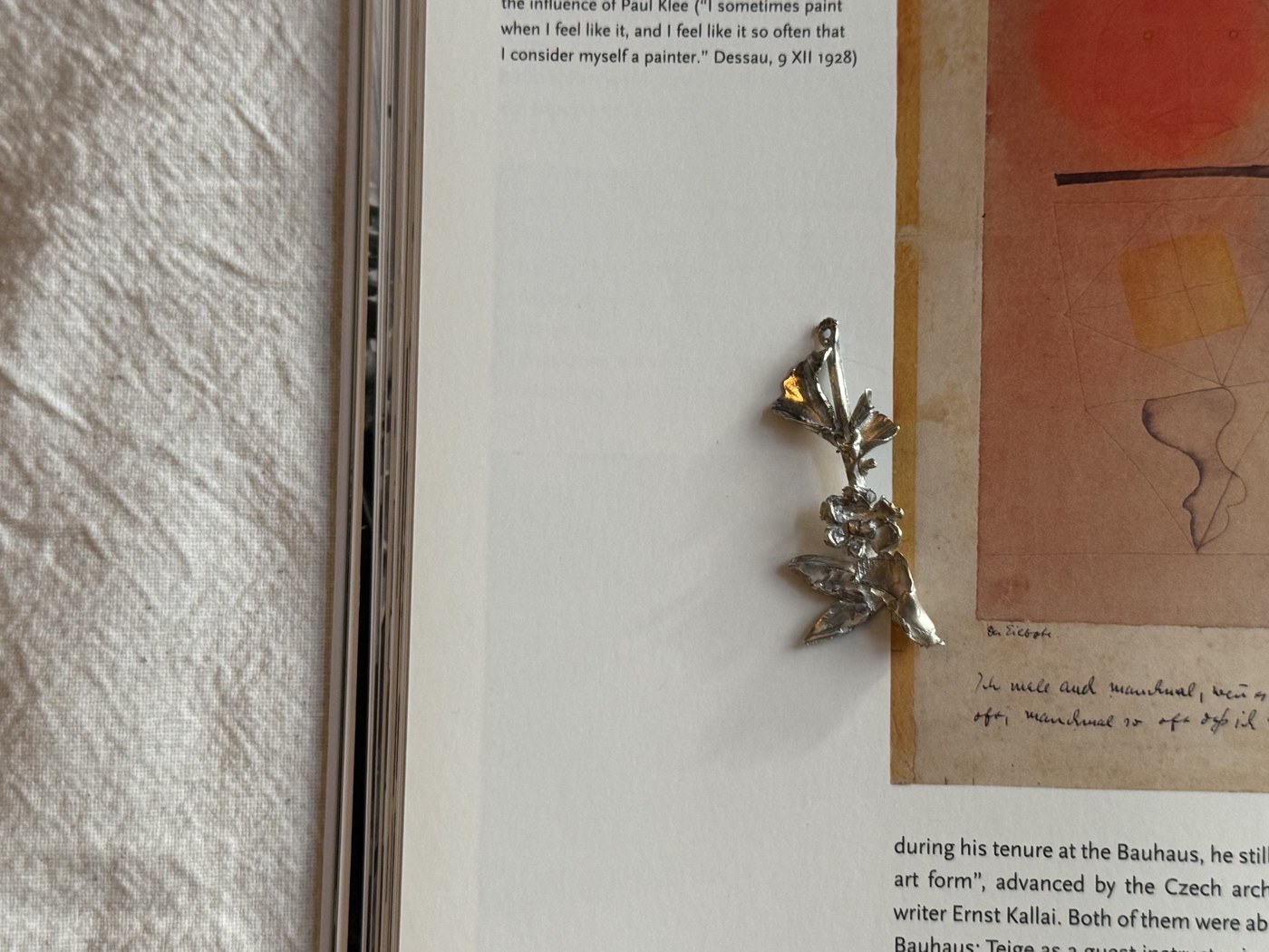 Sof Atelier pendant, resting on an open book